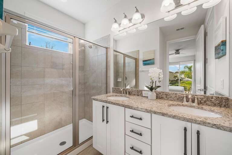- Glass-enclosed shower, dual sinks, and sleek toilet.