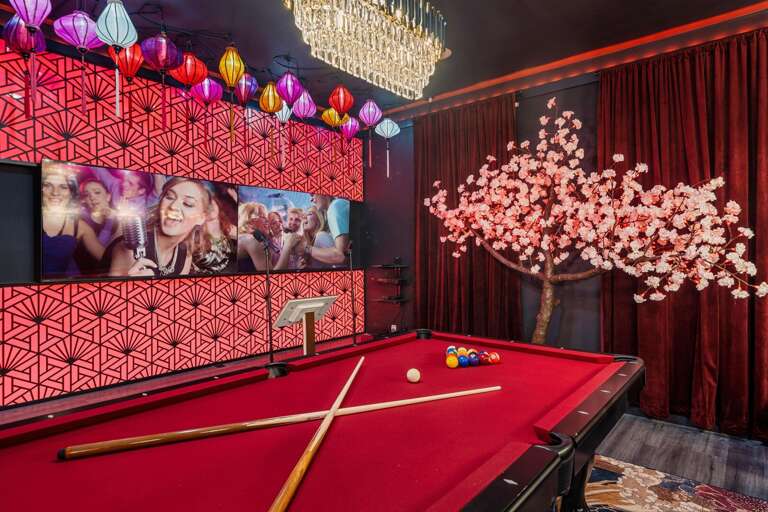 - Stylish entertainment room with cherry blossom mural
- Red-felt pool table
- Pick a mic, pick a song. one unforgettable night
- Mini bar, major vibes.
