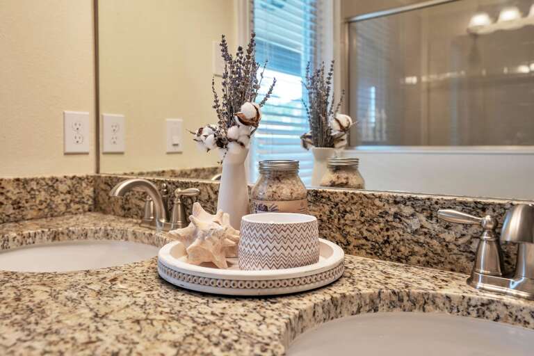 Bathroom with dual sinks and glass enclosed shower