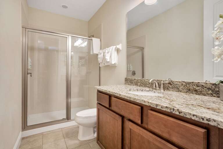 Bathroom with dual sinks and glass enclosed shower