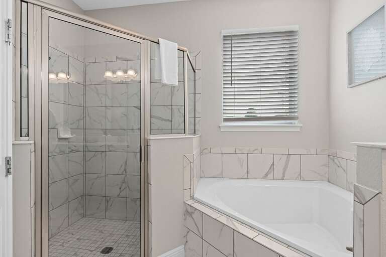 Bathroom w/ glass enclosed shower and tub