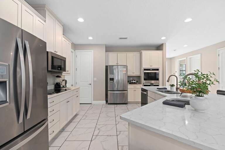 Kitchen area w/ large island and stainless-steel appliances
