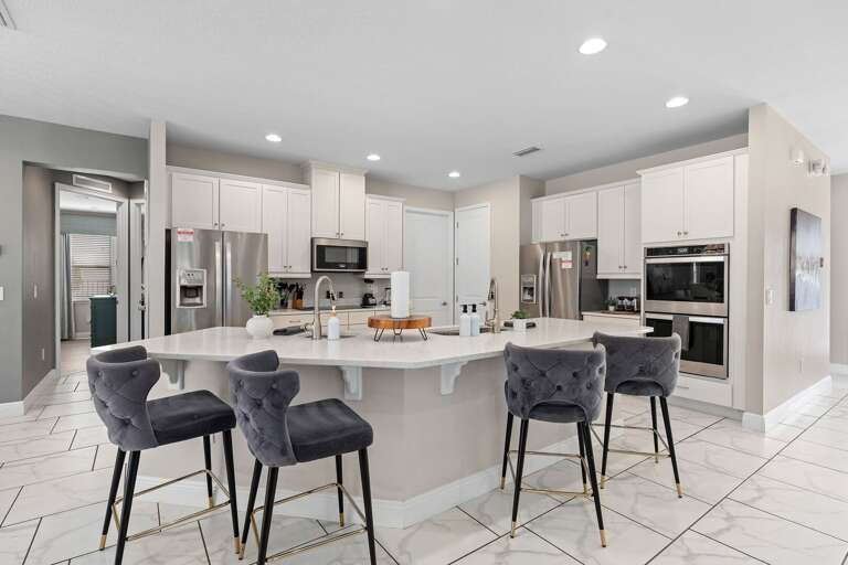 Kitchen area w/ large island and stainless-steel appliances