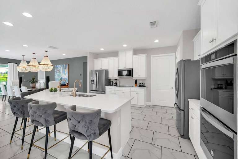 Kitchen area w/ large island and stainless-steel appliances