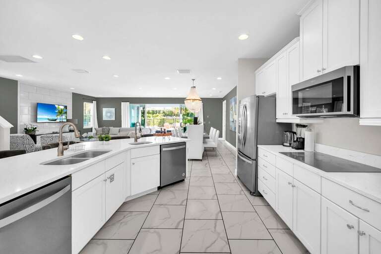 Kitchen area w/ large island and stainless-steel appliances