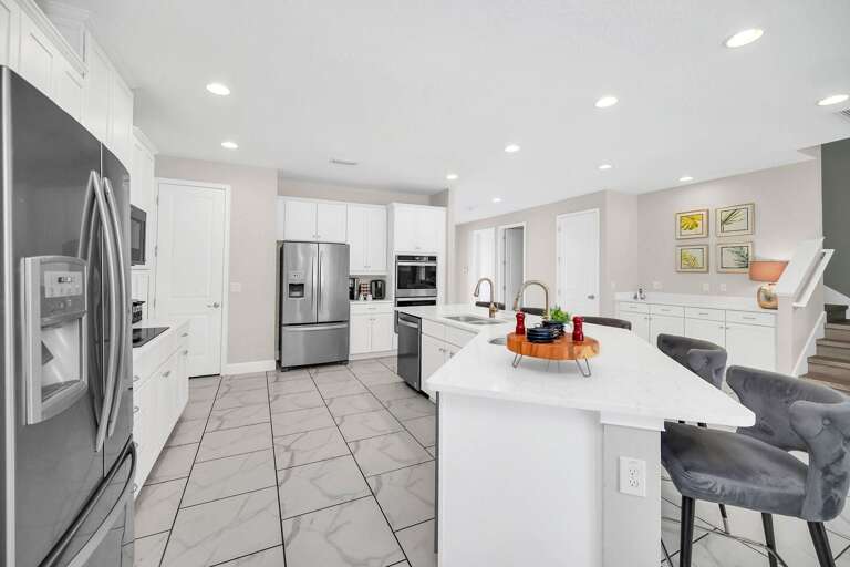 Kitchen area w/ large island and stainless-steel appliances