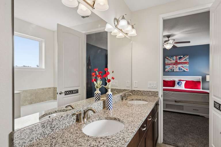 Bathroom with dual sinks and glass enclosed shower
