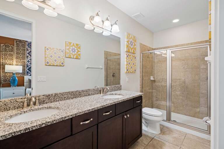 Bathroom with dual sinks and glass enclosed shower
