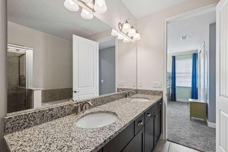 Bathroom with dual sinks and glass enclosed shower