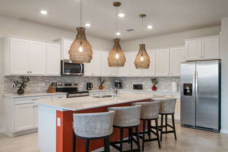 Kitchen area w/ large island and stainless-steel appliances