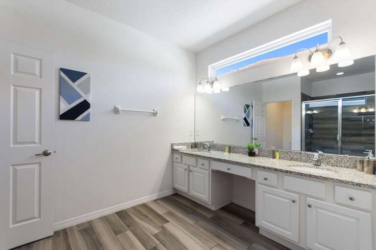 Bathroom w/ Dual Sinks and Glass Enclosed Shower