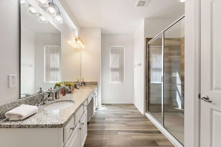 Bathroom w/ Dual Sinks and Glass Enclosed Shower