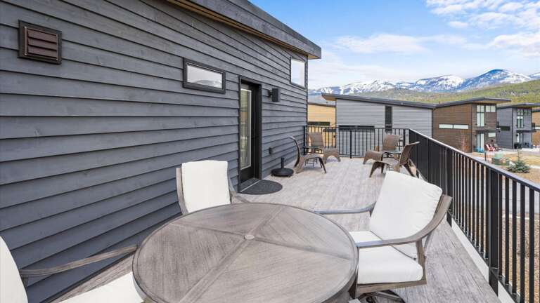 The outdoor patio features two seating areas: a dining space with seating for 4 and a lounging space to enjoy the mountain views.