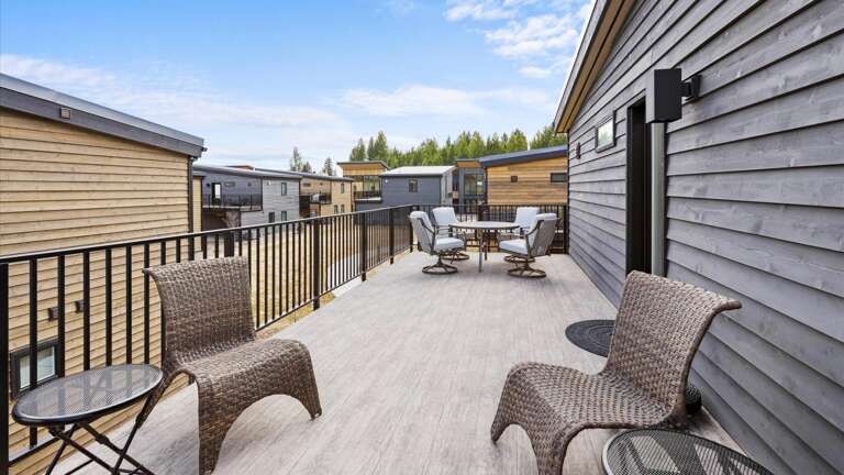The outdoor patio features two seating areas: a dining space with seating for 4 and a lounging space to enjoy the mountain views.
