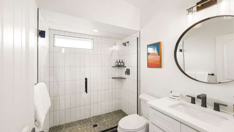 Upstairs bathroom features a vanity, toilet, and walk-in shower.