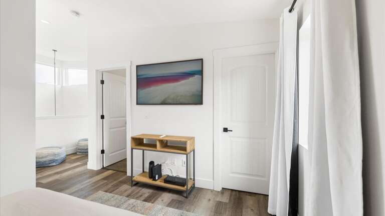 The upstairs bedroom features a luxury queen bed on teh bottom, twin bed on the top, walk-in closet, ensuite bathroom, and HD Frame TV with streaming capabilities.