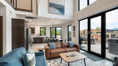 Open concept living room with gas fireplace and SmartTV, dining area, and kitchen with wrap around balcony and hot tub