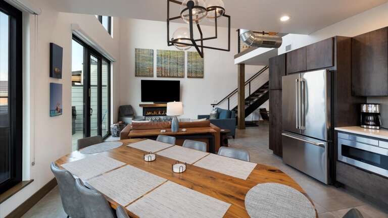 Open concept living room with gas fireplace and SmartTV, dining area, and kitchen with wrap around balcony and hot tub