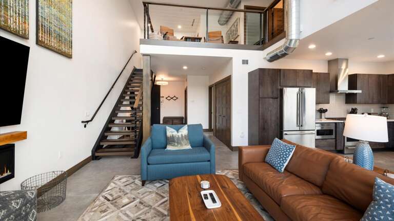 Open concept living room with gas fireplace and SmartTV, dining area, and kitchen with wrap around balcony and hot tub