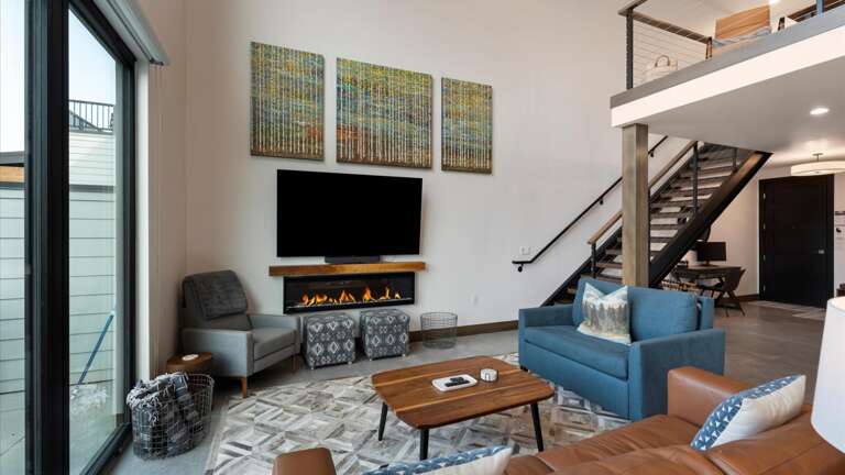 Open concept living room with gas fireplace and SmartTV, dining area, and kitchen with wrap around balcony and hot tub