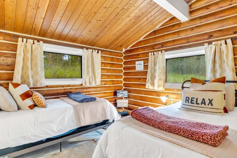 The twin room features two twin beds, a large closet, and vaulted ceilings.