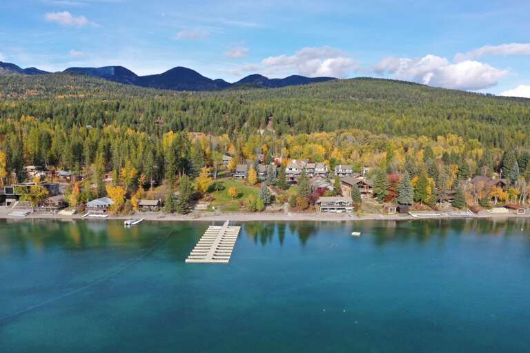 Aerial view of the Mountain Harbor private beach on Whitefish Lake with dock. (Boat slips available with reservation).