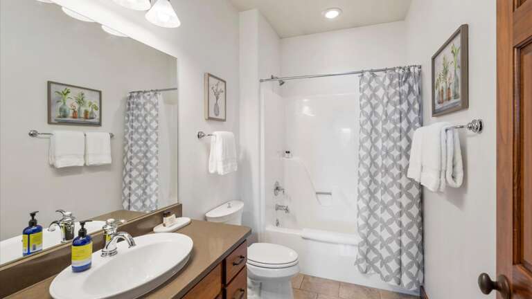 The upstairs bathroom features a shower/tub combination, toilet, and vanity.