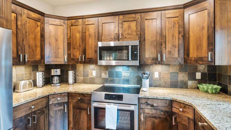 Fully stocked kitchen with top of the line appliances, induction stove top, filtered water system, and mountain and lake views from the kitchen sink.