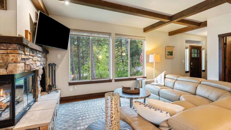 Open concept great room with luxury reclining leather sofa, wood burning fireplace, HDTV with streaming capabilities and alpine views.