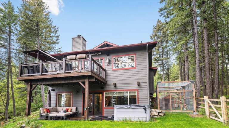 View of the side of the house showcasing the hot tub and the two outdoor entertaining spaces.