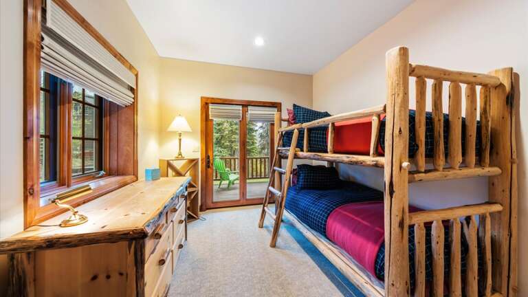 Bunk Room #2 with two twin beds, dresser, and large closet. French doors lead out to patio