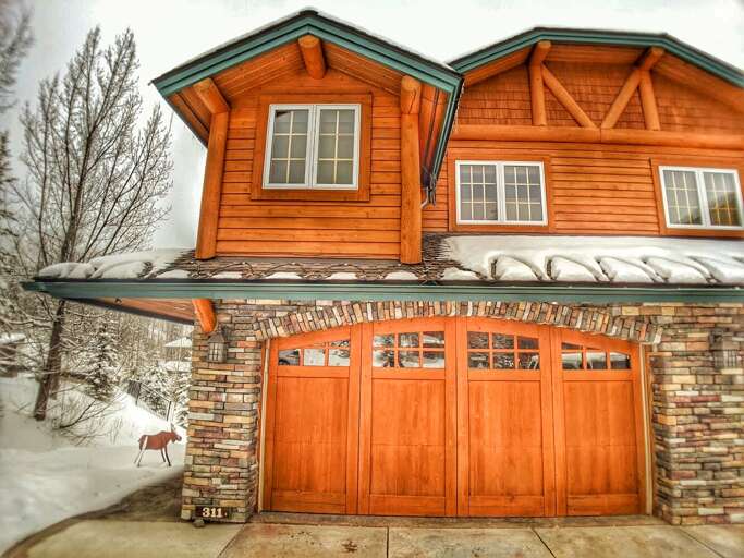 Exterior of home with private two car heated garage and ski access directly out the back door.