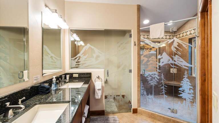 Master Ensuite Bathroom with large walk-in shower with "his and hers" shower heads, double vanity, and private toilet