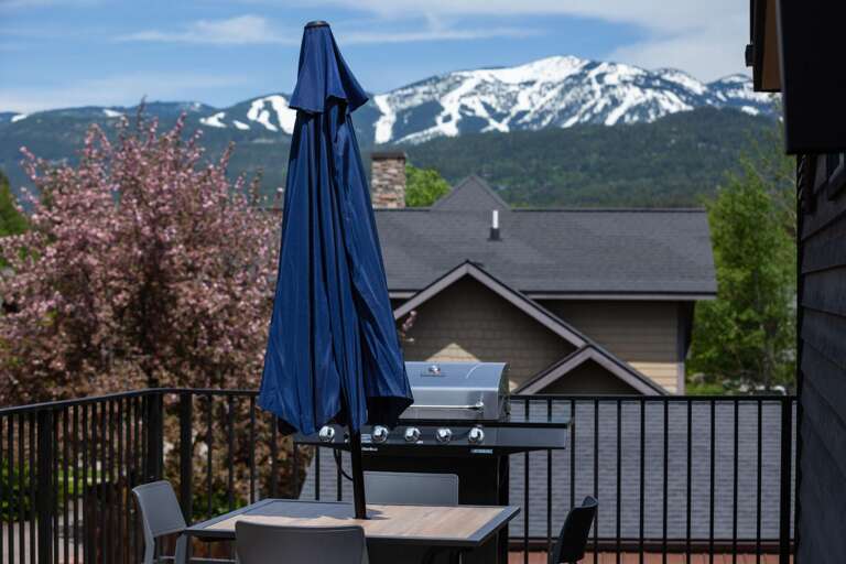 Rooftop balcony with dining area, gas grill (propane provided), and seating area with views of Big Mountain (Whitefish Mountain Resort).