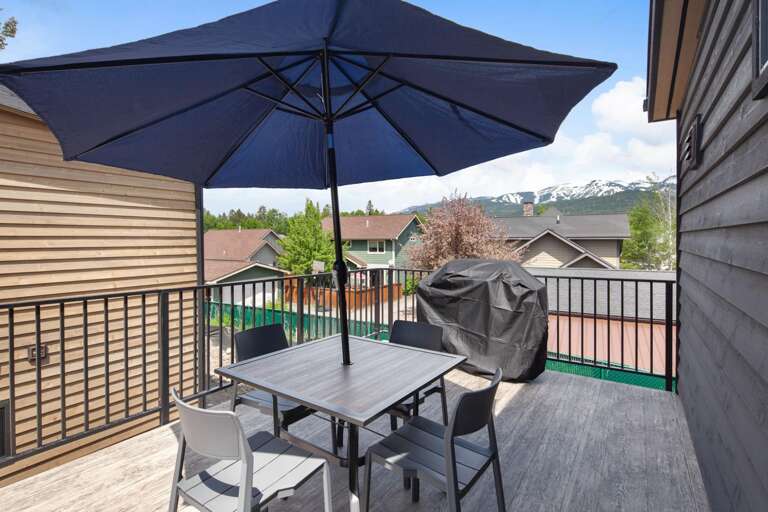 Rooftop balcony with dining area, gas grill (propane provided), and seating area with views of Big Mountain (Whitefish Mountain Resort).