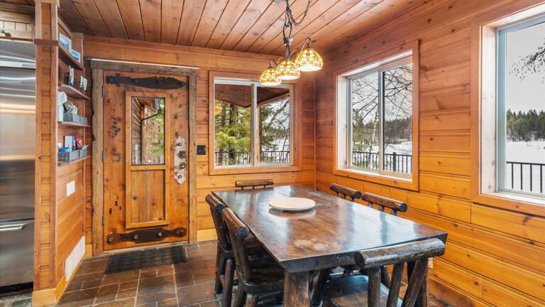 The dining area overlooking Blanchard Lake. Additional seating for 3 at another table, as well as breakfast bar seating for 4.