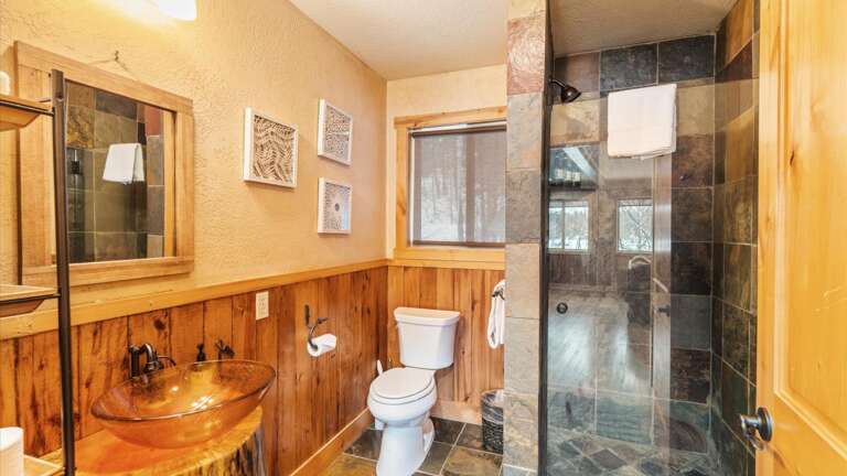 The upstairs full bathroom features a shower, toilet, and custom vanity.