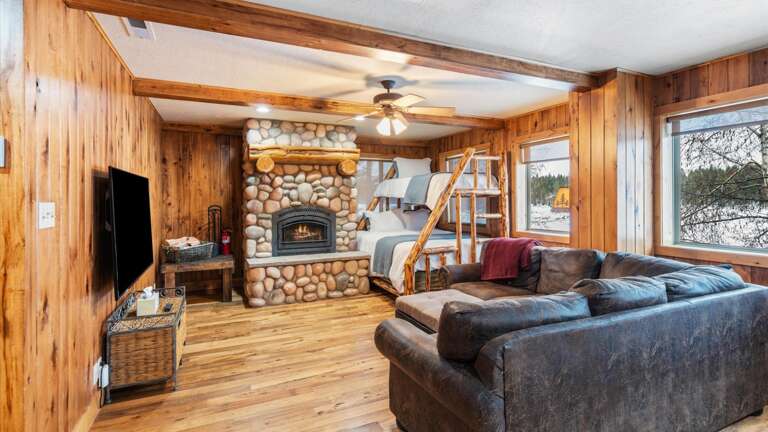 The upstairs living room features an HDTV with streaming capabilities, fireplace, seating, and another bunk bed with a queen mattress on the bottom and a twin bed on the top. Lake views for days!