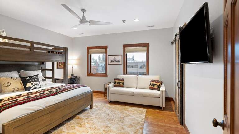 The bunk room features a king bed on the bottom bunk, twin XL bed on the top bunk, a queen sofa sleeper, desk area, walk-in closet, and a HDTV with streaming capabilities.