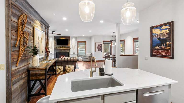 he fully stocked kitchen features custom cabinetry, marble countertops, high-end appliances, and an island/breakfast bar with seats for two
