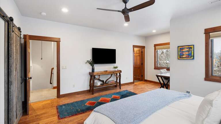 The master suite includes a luxury king bed, walk-in closet, desk area, ensuite bathroom, HDTV with streaming capabilities.