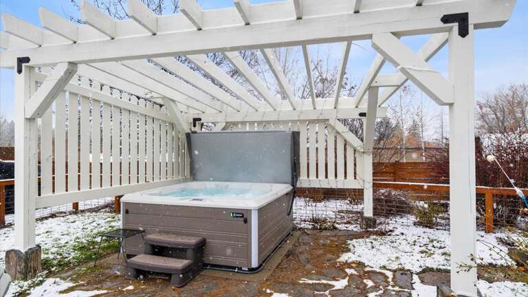 Step outside into the large private backyard area which features a brand new 6-person hot tub under a pergola wrapped in mood-setting string lights along with a gas grill and firepit seating area.
