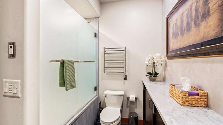 The upstairs bathroom features a large vanity with tons of storage, toilet, and shower/tub combination.