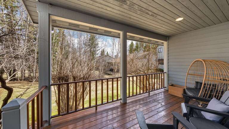 Balcony with cozy seating area, gas grill (propane provided), and backyard access