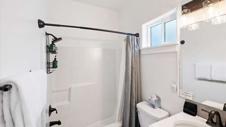 The bunk room ensuite bathroom features a shower/tub combination, sink, and vanity.