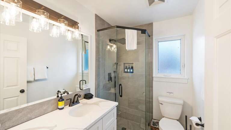 Newly remodeled main floor bathroom with luxury rain shower, vanity, and toilet.