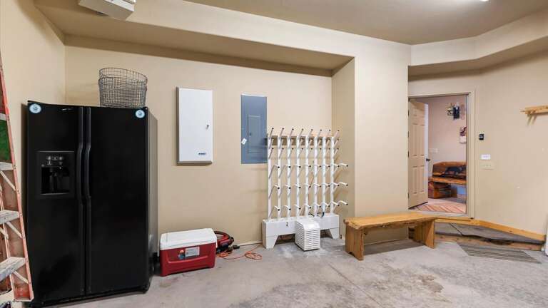 2 car garage with extra refrigerator, industrial boot warmer system, and tons of ski racks