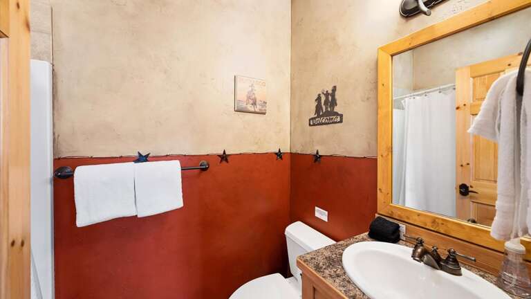 Entry level floor bedroom ensuite bathroom with shower/tub combination, toilet,