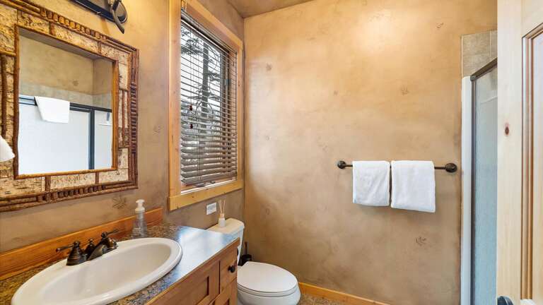 Main floor bedroom #1 ensuite bathroom with shower, vanity, and toilet.