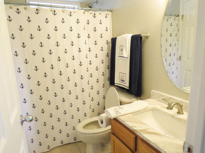 Bathroom Interior With Anchor Pattern Shower Curtain And Vanity
